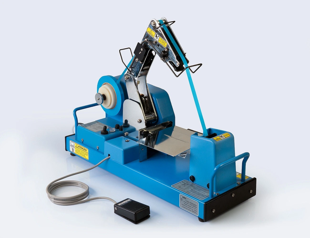 Enfardadora Suliflex modelo DBA50V azul, utilizada para agrupar e compactar produtos com fitas adesivas industriais, equipada com pedal elétrico e estrutura metálica reforçada.